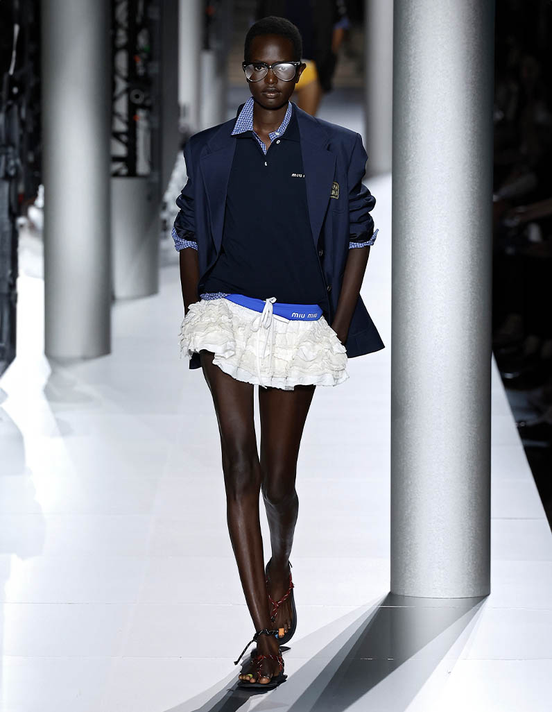 Model walks down Miu Miu runway wearing white tennis co-ord